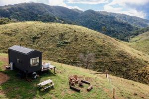 a black tiny house sitting on top of a hill at Aahana in Pinbarren