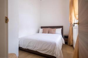 a bedroom with a bed with white sheets at Cove Service Apartments at Bugis in Singapore