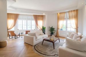 a living room with two white couches and a table at Cove Service Apartments at Bugis in Singapore