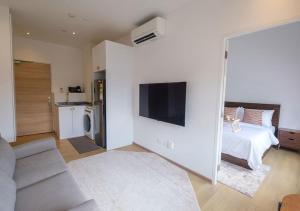 a white room with a bed and a tv at Cove Service Apartments at Bugis in Singapore