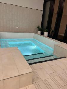 a swimming pool with blue water in a building at 2bedroom city central appletv Homepod pool sauna in Melbourne +5 photos