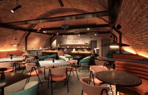 a restaurant with tables and chairs and a brick wall at Hampton By Hilton Manchester City Centre in Manchester