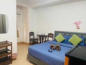 a bedroom with a blue bed with two hats on it at Miss Hong House in Ko Samed