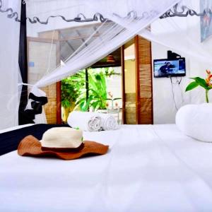 a white bed with a hat on top of it at Villa Kyda - 2 Min walk to the Beaches! in Tangalle