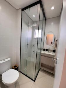 Praia Grande Boqueirão في برايا جراندي: حمام مزود بمرحاض ودش زجاجي