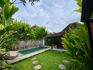 a backyard with a swimming pool and green grass at Ubud jungle House behind bintang supermarket ubud in Ubud