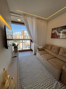 Praia Grande Boqueirão في برايا جراندي: غرفة معيشة مع أريكة ونافذة كبيرة