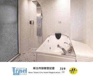 a bathroom with a bath tub and a shower at Thinker Hotel in Yingge