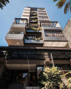 メデジンにあるSonata 44 Hotel Laurelesのバルコニーと植物が備わる高層ビル