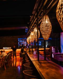 メデジンにあるSonata 44 Hotel Laurelesの木製のテーブルの上に照明が吊るされたバー +154枚の写真