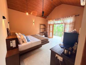 a bedroom with a bed and a television in it at Whispering Wave Tangalle in Tangalle