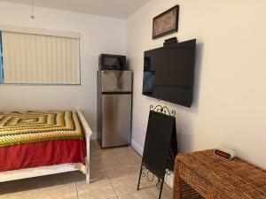 a room with a bed and a tv on a wall at El Shaddai Faithfully Beach in Hollywood +4 photos