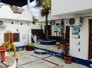a house with a courtyard with a palm tree at Penguin Hostel in Puerto Ayora