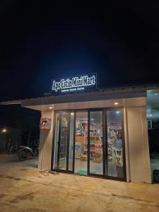 een winkel met een uithangbord erop 's nachts bij Rooms in Apo-estin in Cangatuyom +8 foto's