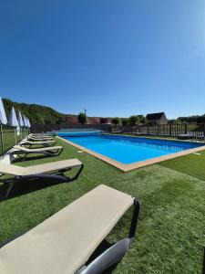 a row of lounge chairs next to a swimming pool at Camping 3 étoiles - Piscine - eeicbi in Le Change