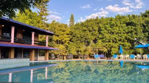 a house with a swimming pool and trees at Los Cruxes in Tepoztlán