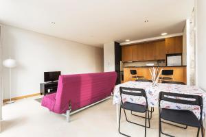 a dining room with a pink couch and a table at Bright Luxury Apartment in Viana do Castelo