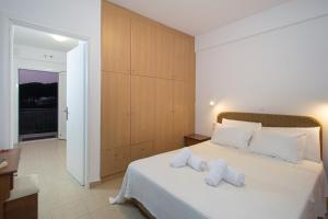 a bedroom with a large white bed with two pillows at Romanos Beach Villas in Romanu