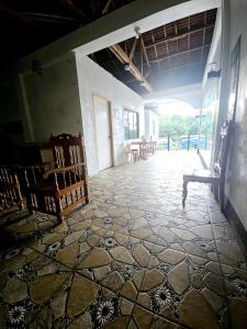 een kamer met een tegelvloer, stoelen en een tafel bij Rooms in Apo-estin in Cangatuyom