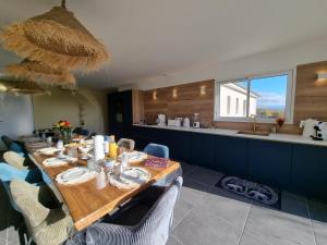 Un comedor con una mesa larga con sillas. en Gîte spacieux 12 pers à Saint-Germain-Laval - Confort et charme - FR-1-496-378, en Saint-Germain-Laval