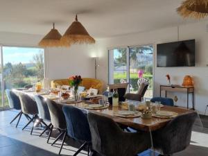 Un comedor con una mesa larga y sillas. en Gîte spacieux 12 pers à Saint-Germain-Laval - Confort et charme - FR-1-496-378, en Saint-Germain-Laval