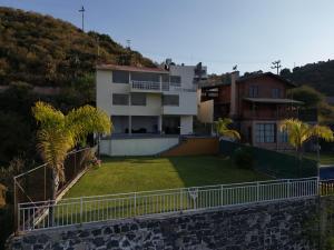 ein Haus auf einem Hügel mit einem Hof in der Unterkunft Casa del Lago in Presa Requena