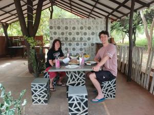 a man and a woman sitting at a table at Yala Thaman Katharagama in Kataragama