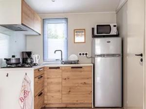 a kitchen with a refrigerator and a microwave at Mobil-home à Pordic 4 pers. avec Terrasse - API-1-52-1204 in Pordic +25 photos