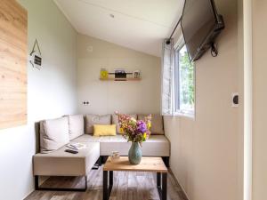 a living room with a couch and a table at Mobil-home à Pordic 4 pers. avec Terrasse - API-1-52-1204 in Pordic