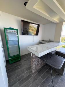 ein Raum mit einer Theke und einem Tisch und einem Fenster in der Unterkunft Casa del Lago in Presa Requena