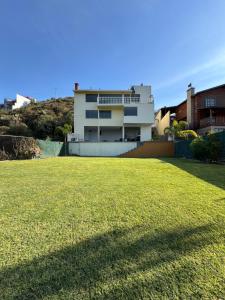 ein Haus mit einer großen Wiese davor in der Unterkunft Casa del Lago in Presa Requena + 9 Fotos