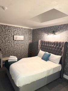 a bedroom with a large bed with a padded headboard at West Coates Mansion in Edinburgh +9 photos