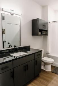 a bathroom with a sink and a mirror and a toilet at Luxury Mountain Views at Prime Location Huntsville in Huntsville
