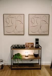 a shelf with plants and two pictures on the wall at Luxury Mountain Views at Prime Location Huntsville in Huntsville