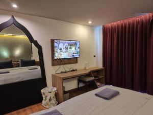 a bedroom with a bed and a desk and a television at 4 Floor - Pool view Studio room at TBHR near Kata beach in Kata Beach