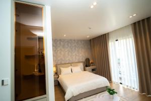 ein Schlafzimmer mit einem Bett und einem großen Fenster in der Unterkunft T-Moon Homestay in Binh Hai + 9 Fotos