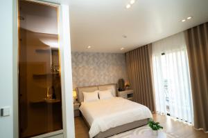 ein Schlafzimmer mit einem weißen Bett und einem Fenster in der Unterkunft T-Moon Homestay in Binh Hai