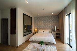 ein Schlafzimmer mit einem großen Bett und einem Tisch in der Unterkunft T-Moon Homestay in Binh Hai