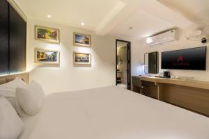 a bedroom with a large white bed and a desk at A25 Hotel - 19 Chả Cá in Hanoi