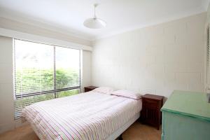 Blueys Beach Villa Manyana 24 في بلويز بيتش: غرفة نوم بيضاء مع سرير ونافذة