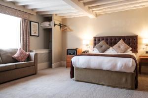 1 dormitorio con 1 cama grande y 1 sofá en The Red Lion Hotel, en Hillingdon