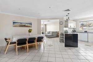 een keuken en woonkamer met een tafel en stoelen bij Sandy Serenity - Pet Friendly Beach House in The Entrance