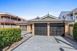 een huis met twee garagedeuren op een oprit bij Sandy Serenity - Pet Friendly Beach House in The Entrance