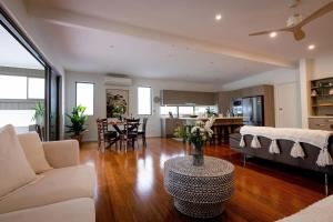 a living room with a couch and a table at The Emerald Bower Peaceful Kilaben Bay Hideaway in Rathmines