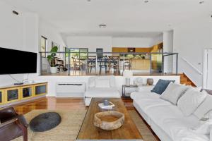 a living room with a white couch and a table at Hilltop Hideaway Family Escape in Merewether