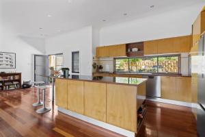 Hilltop Hideaway Family Escape في Merewether: مطبخ كبير مع دواليب خشبية ونافذة كبيرة