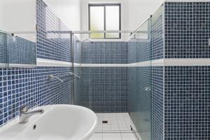 Hilltop Hideaway Family Escape في Merewether: حمام من البلاط الأزرق مع حوض استحمام وحوض استحمام +36 صورة
