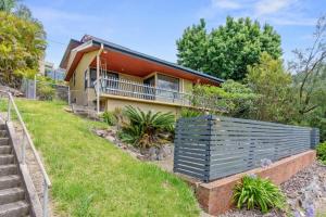 Hilltop Hideaway Family Escape في Merewether: منزل امامه سياج