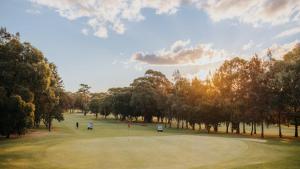Hilltop Hideaway Family Escape في Merewether: اطلاله على ملعب قولف مع اشجار وخضر