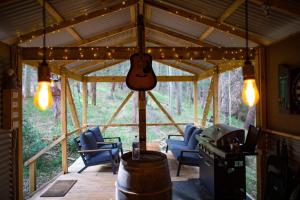 a living room with a guitar hanging from a tent at Kookaburra Ridge in Wyee +23 photos